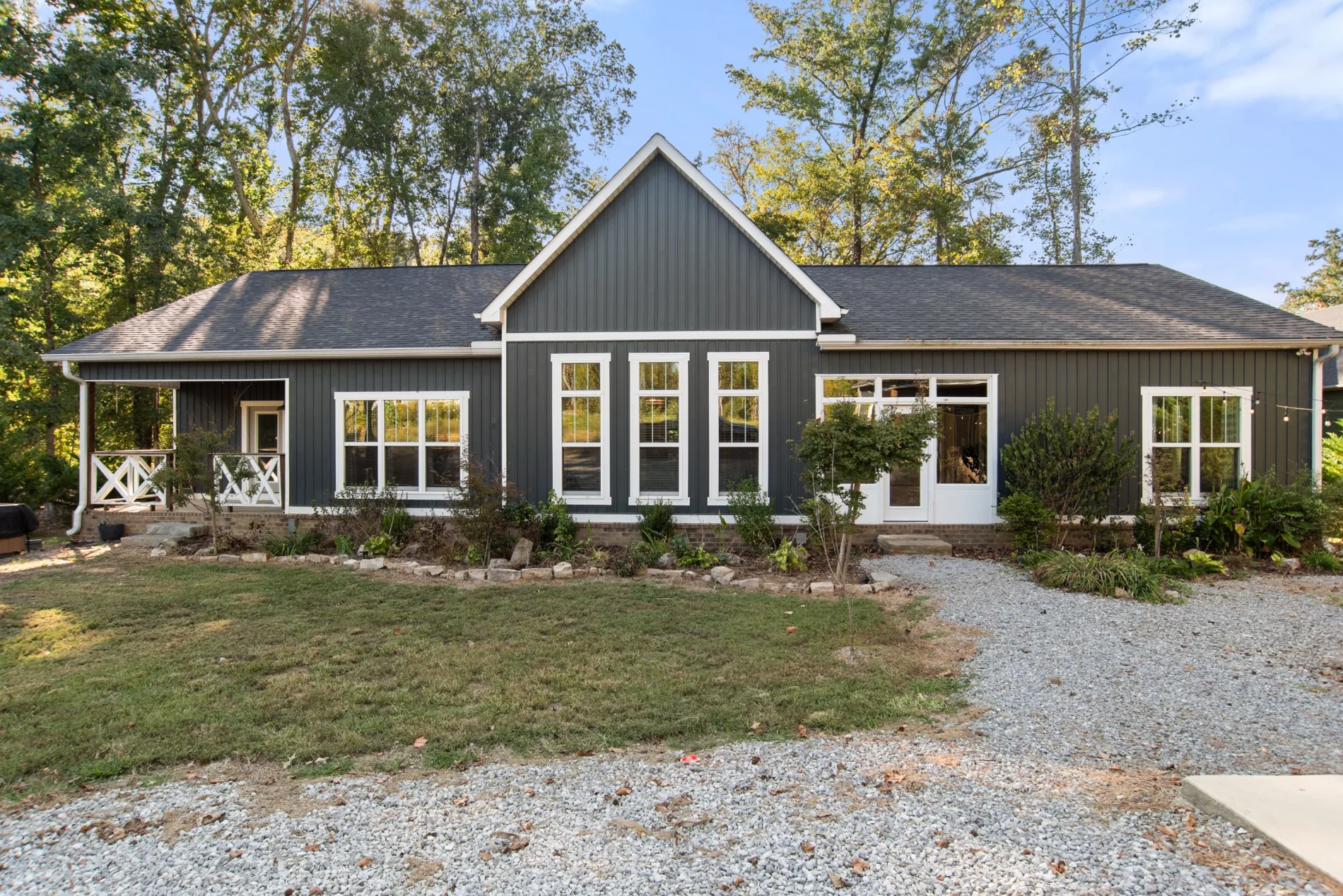 Wide front exterior view of charcoal-gray house with white trim