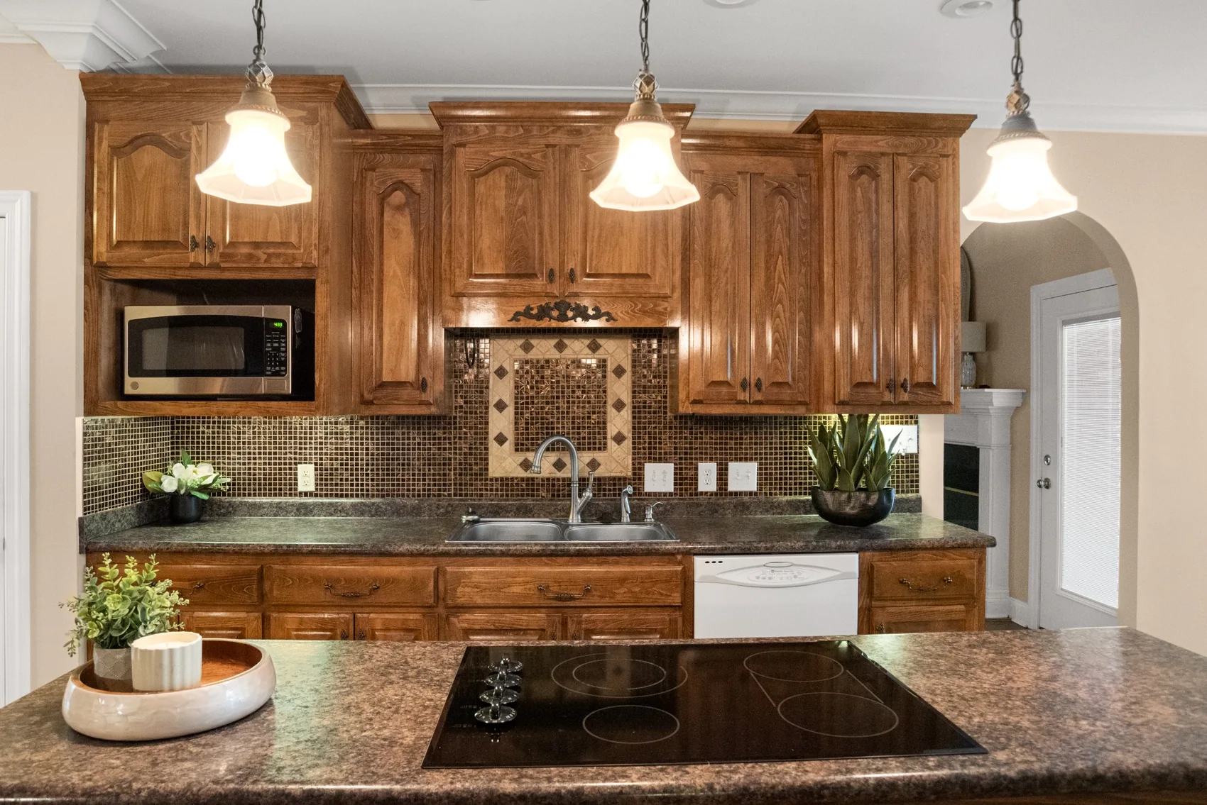 Kitchen island and decorative tile backsplash with wood cabinetry